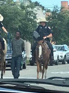 A NY Policeman Leading a Black Man In