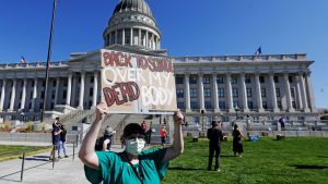 Teacher holding sign that says over my dead body